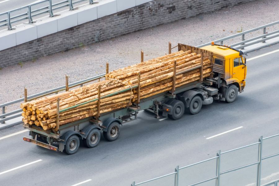 an aerial shot of a semi truck hauling logs