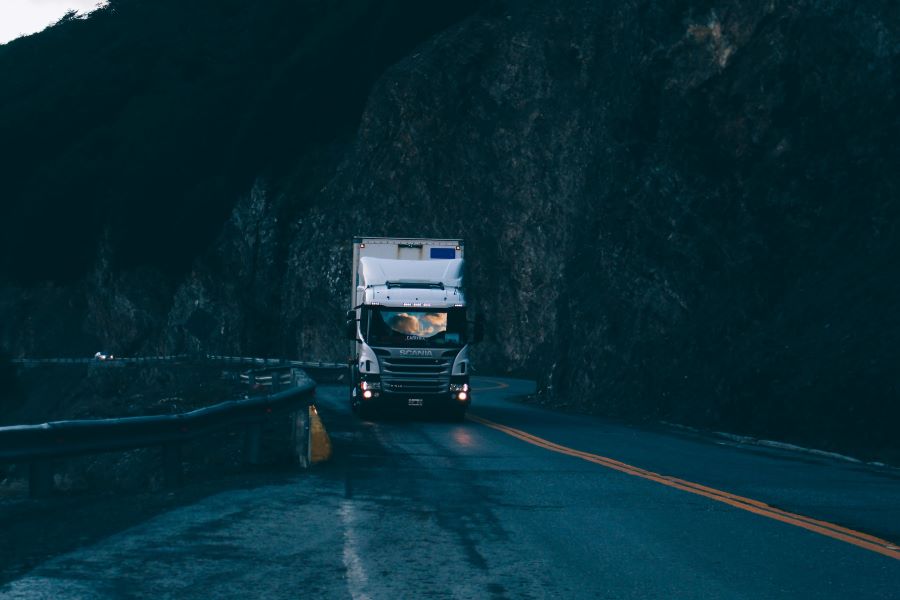 Semi truck driving on dark and rainy road